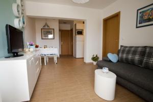 a living room with a couch and a tv and a table at Apartments Vrbnik (879) in Vrbnik