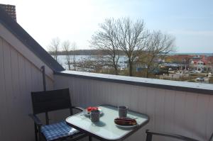 una mesa y sillas en un balcón con vistas al agua en Ferienwohnung mit Ostseeblick in Rerik, en Rerik