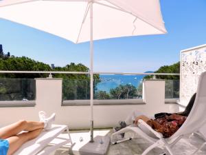 a man laying in a chair under an umbrella at Hotel Byron in Lerici