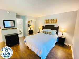 a bedroom with a large white bed with blue sheets at Slopeside Blue Mountain Condo - Wifi, Linens/Towels, Ski In/Out in Blue Mountains