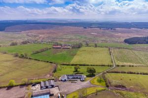 an aerial view of a farm in the middle of a field at Meadowhead Cottage, Traditional Scottish Cottage in Waterside