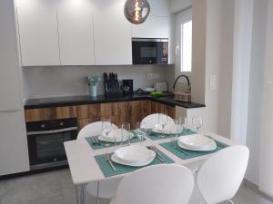 een keuken met een witte tafel met witte stoelen en een aanrecht bij Rentaly Holidays Apartamento Natura Mar Almería in Almería