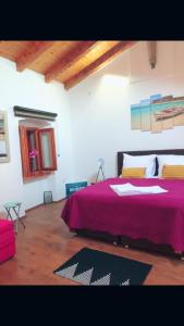 a bedroom with a large bed with a purple blanket at Krk centar in Krk