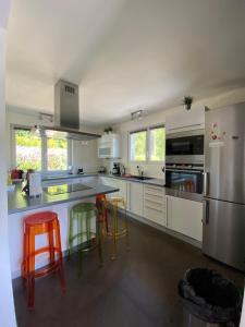 kuchnia z białymi szafkami i kolorowymi stołkami barowymi w obiekcie River Villa with amazing view + Jacuzzi, Garden, Forest access w mieście Vétraz-Monthoux