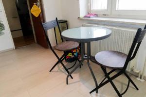 a table and two chairs sitting in a kitchen at Vacation Apartment In The Black Forest in Villingen-Schwenningen +5 photos