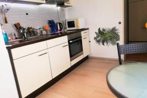 a kitchen with white cabinets and a table and a sink at Vacation Apartment In The Black Forest in Villingen-Schwenningen