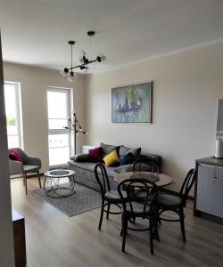 uma sala de estar com um sofá, mesas e cadeiras em VIEW 20 APARTAMENT em Giżycko
