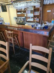 bar z krzesłami i ladą w restauracji w obiekcie Apartments Hugo w mieście Malinska