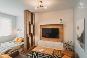 ein Wohnzimmer mit einem Bett und einem Flachbild-TV in der Unterkunft Sunrise Luxury Apartment in Bitola