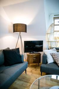 Una sala de estar con un sofá azul y un televisor. en Apartment Aussee- Hallsatt Salzherrenhof- Küche, WLAN, Netflix, en Bad Aussee 43 fotos más