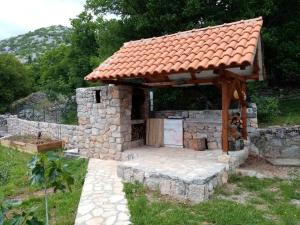 a stone building with a red roof and a patio at Starigrad kod Senja 60/a in Starigrad