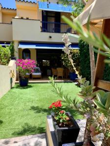 a garden with green grass and flowers and a house at Meloneras ideal in Meloneras