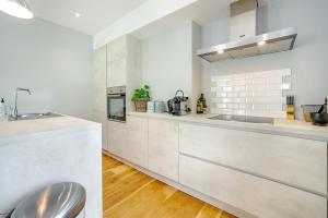 a white kitchen with a sink and a counter at Quai de l'Ourthe in La-Roche-en-Ardenne