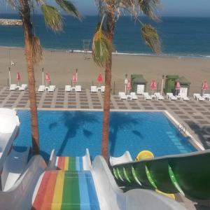 ガジパシャにあるBülent Kocabaş-Selinus Beach Club Hotelのビーチの横のスライド付きスイミングプール