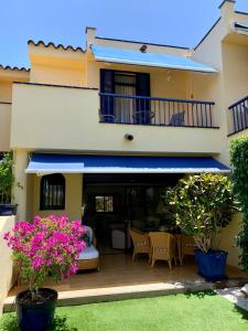een huis met een balkon met roze bloemen in een tuin bij Meloneras ideal in Meloneras