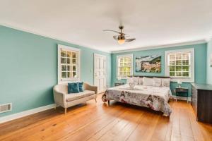 Schlafzimmer mit blauen Wänden, einem Bett und einem Stuhl in der Unterkunft The Luxe 5BR ATL Oasis with private pool in Conyers
