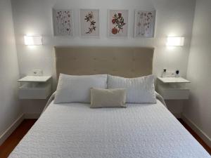 - une chambre avec un lit et 2 tables de nuit blanches dans l'établissement APARTAMENTO PASEO DE LA RIVERA, à Cordoue