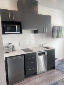 a kitchen with stainless steel appliances and black cabinets at Ramada by Wyndham Wellington Taranaki Street in Wellington
