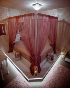 sypialnia z łóżkiem z różowymi zasłonami w obiekcie Studio apartman Dona w mieście Nova Varoš