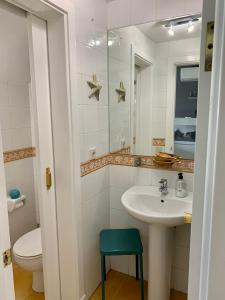 ein Badezimmer mit einem Waschbecken, einem WC und einem Spiegel in der Unterkunft Meloneras ideal in Meloneras