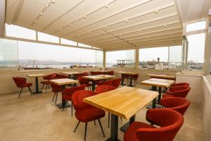 a restaurant with wooden tables and red chairs at Astan Hotel Galata in Istanbul