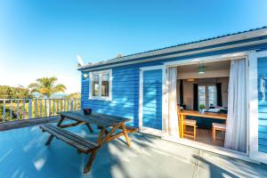 a blue house with a picnic table on a deck at The Butterfly Bach - Surfdale Holiday Home in Surfdale