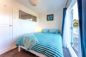 A bed or beds in a room at The Butterfly Bach - Surfdale Holiday Home