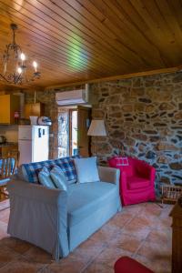 uma sala de estar com um sofá e uma parede de pedra em Quinta de Recião em Lamego