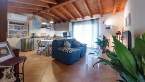 sala de estar con sofá azul y cocina en Casa Vacanze " IS MERIS " en Capitana