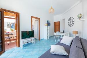 a living room with a couch and a television at Holiday Home La Notte Stellata in San Vito lo Capo