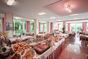 a buffet line with food on display in a restaurant at Hotel Silver in Milano Marittima