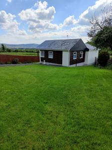 uma casa num quintal com um relvado verde em The Bungalow Self-catering Accommodation em Ballybofey