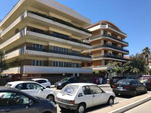 un parking avec des voitures garées devant un bâtiment dans l'établissement Alma Luxury suite, à Pescara