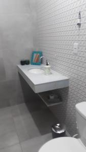 a white bathroom with a sink and a toilet at Recanto das Palmeiras Praia da Longa in Angra dos Reis