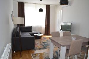 uma sala de estar com um sofá e uma mesa em Comfy New Apartment em Sarajevo