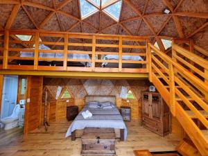 ein Schlafzimmer mit einem Bett in einer Holzhütte in der Unterkunft Glamping sede campestre Mirador de Pueblo Viejo in Guatavita