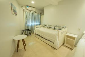 a bedroom with a bed and a table in it at Apart Hotel Ayres De Termas in Termas de Río Hondo +53 photos