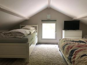 a attic bedroom with two beds and a window at Chambon-sur-Lac in Chambon-sur-Lac