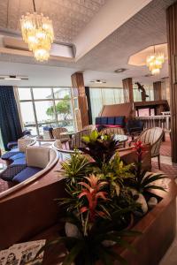 a hotel lobby with chairs and tables and plants at Hotel San Pietro in Cesenatico