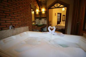 uma banheira grande com formato de coração em Pousada Sunset em Praia do Rosa