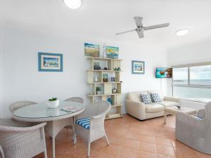 a living room with a table and chairs and a couch at Avalon 1 in Yamba