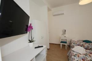 sala de estar con TV de pantalla plana grande en la pared en Casa Calieri, en Tropea