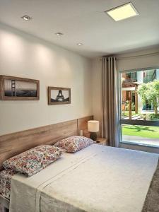 a bedroom with a bed and a large window at Guarajuba Porto Smeralda Village C02, térreo - GUARAJUBA TEMPORADA, viva mais de uma experiência de hospedagem conosco! 130m da praia in Guarajuba