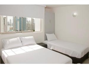 zwei Betten in einem Zimmer mit zwei Fenstern in der Unterkunft III NICE 2 BEDROOM APARTMENT Bocagrande in Cartagena de Indias + 12 Fotos