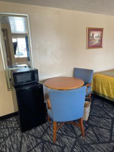 um quarto com uma mesa e duas cadeiras e uma cama em Riverton Inn & Suites Riverton em Riverton