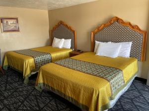 a hotel room with two beds with yellow sheets at Riverton Inn & Suites Riverton in Riverton