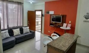 sala de estar con sofá y TV en Garzota Suites Airport, en Guayaquil