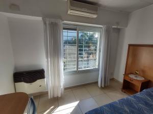 a bedroom with a bed and a large window at Studio Estrada Escobar in Belén de Escobar