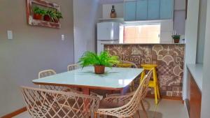 uma sala de jantar com mesa e cadeiras e uma cozinha em Guarajuba Village Verano A01, térreo - GUARAJUBA TEMPORADA, viva mais de uma experiência de hospedagem conosco! em Guarajuba