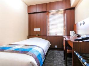 a hotel room with a bed and a desk at Central Hotel Okayama in Okayama